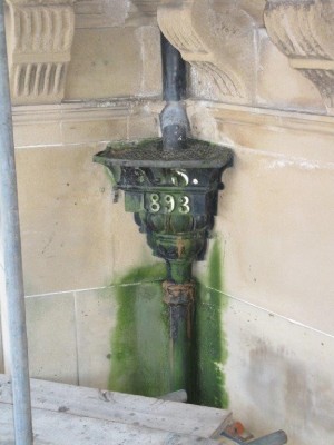 Cast iron downpipe in poor repair causing leaking, damp and algae growth